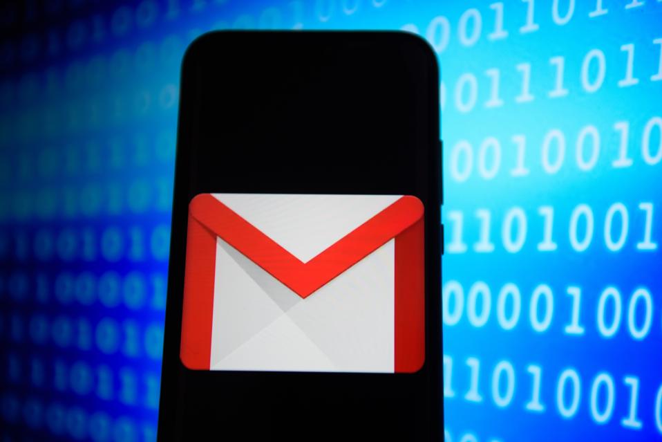 Gmail logo is seen on smartphone with a binary code background in blue