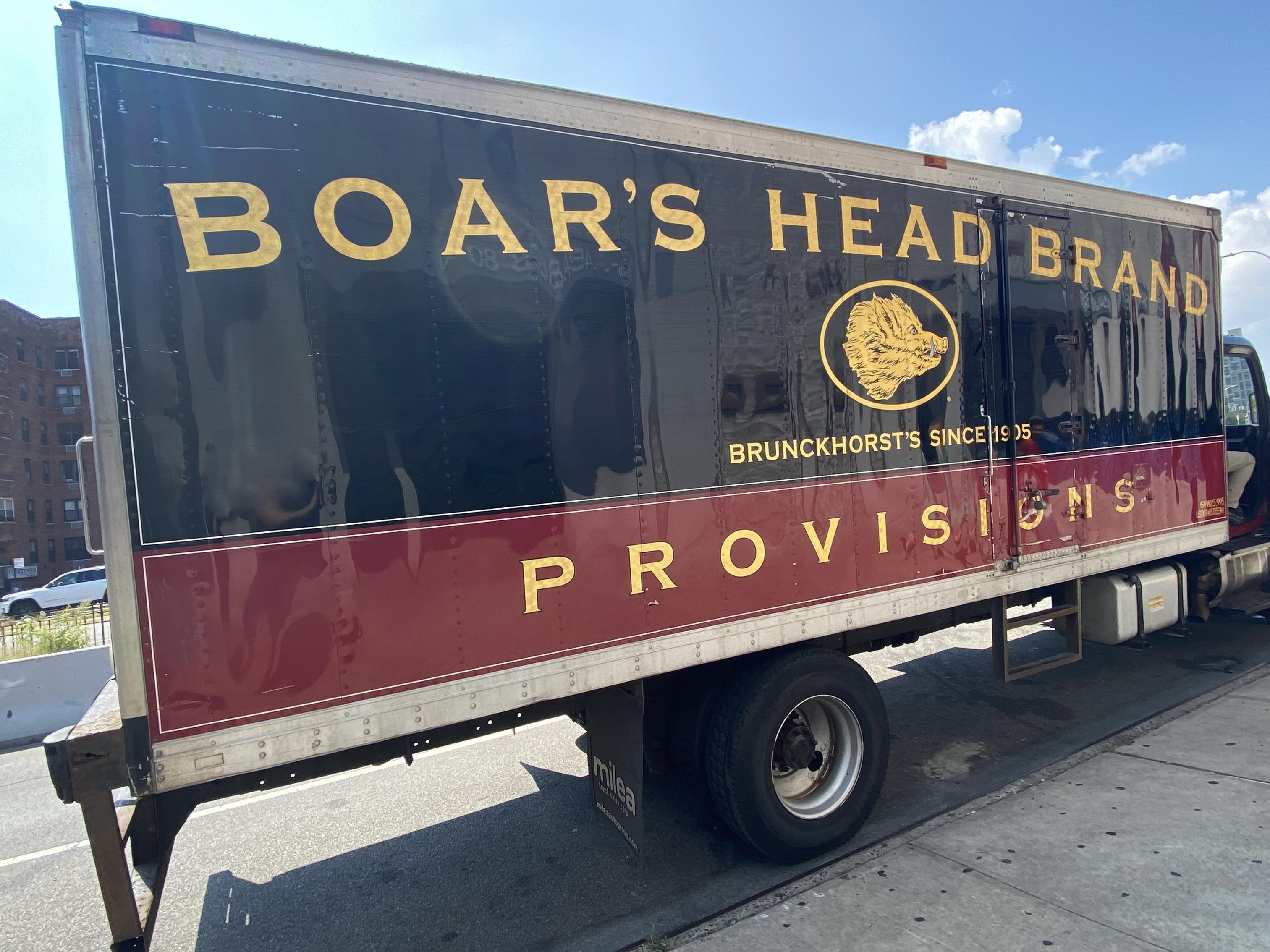A Boar's Head deli meat truck with a black, red and gold logo on the side.