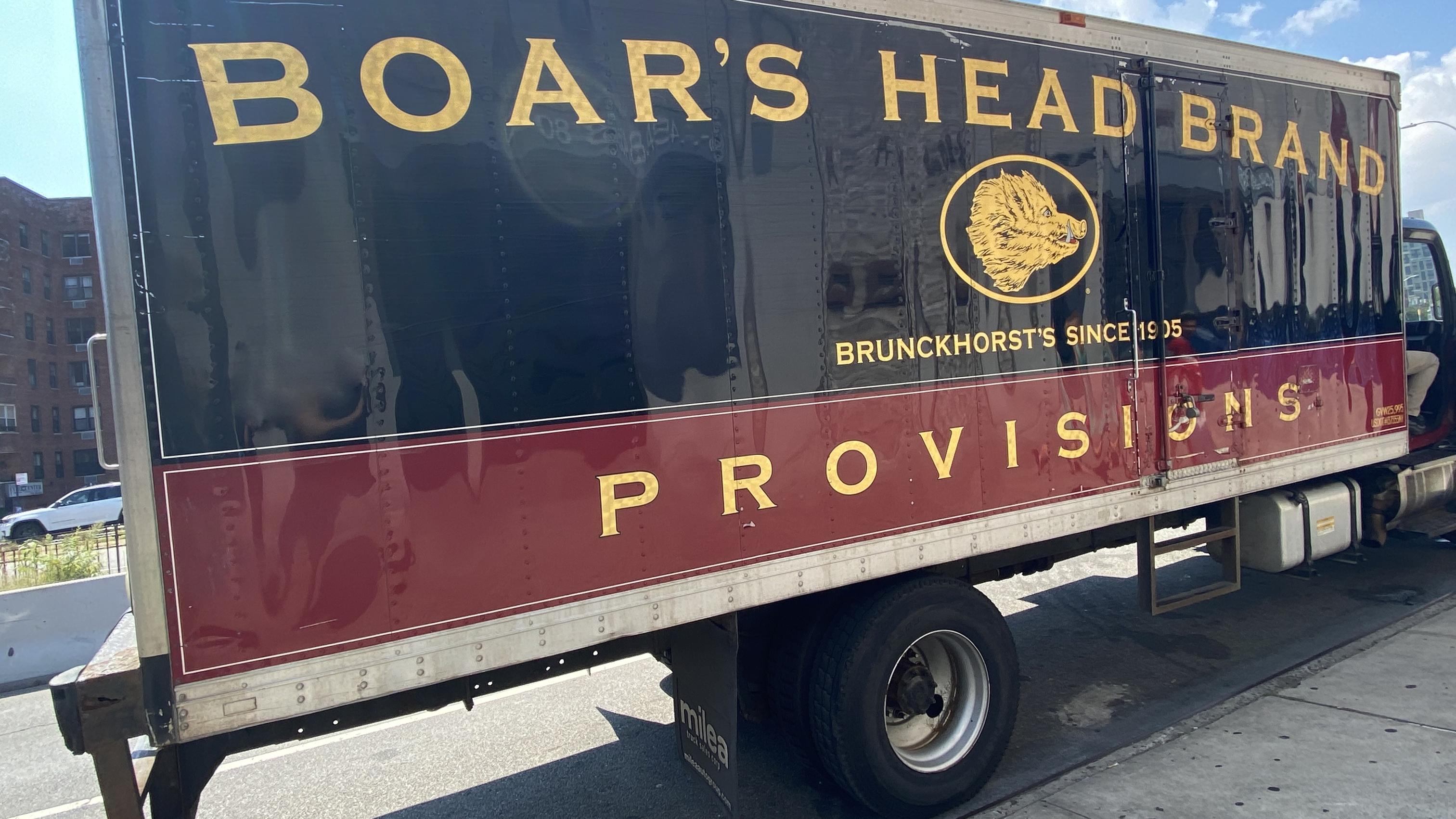 A Boar's Head deli meat truck with a black, red and gold logo on the side.