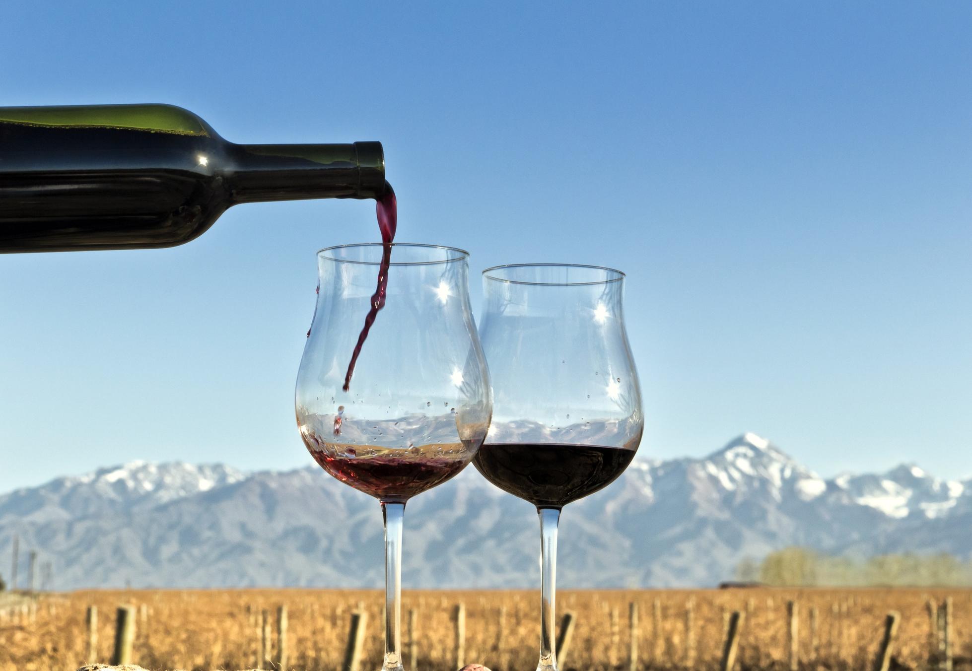 Red wine being poured with a mountain range in the back
