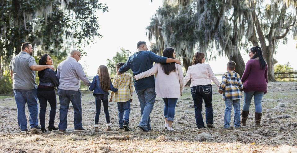 A large family locking arms and hands at a campground