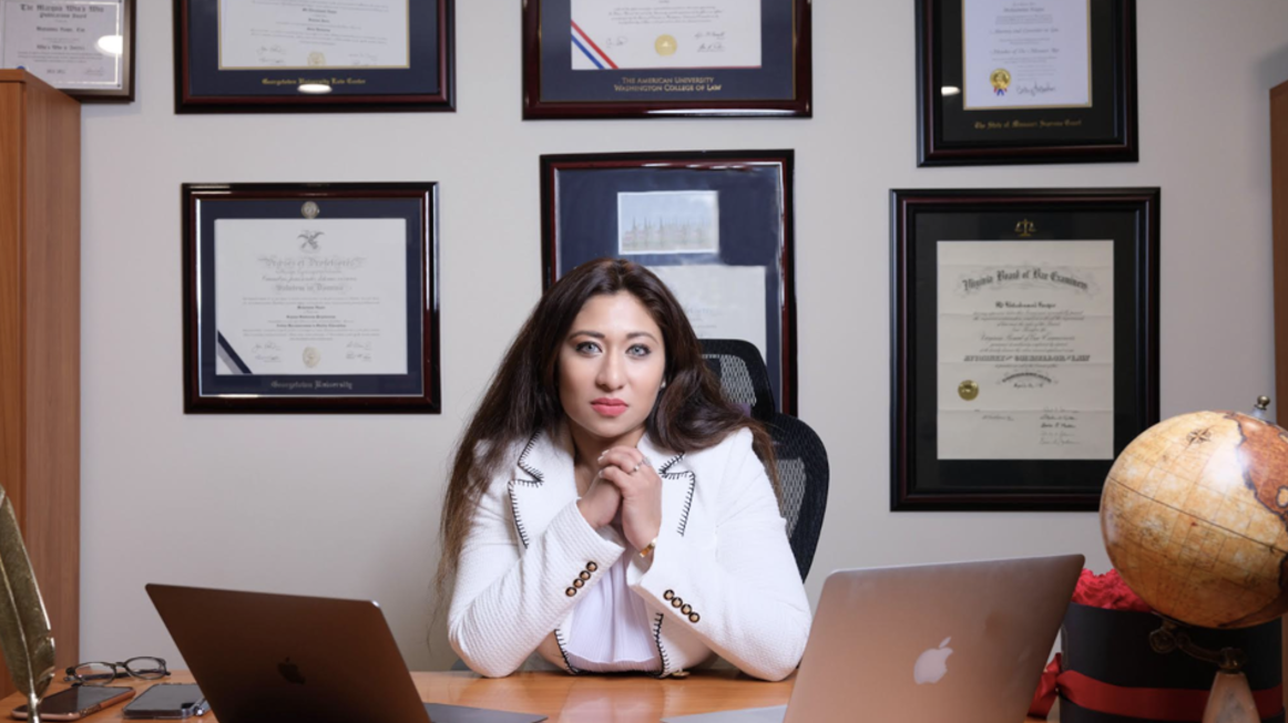 A portrait of Tony Roma's CEO sitting at a desk with two computers in front of her.