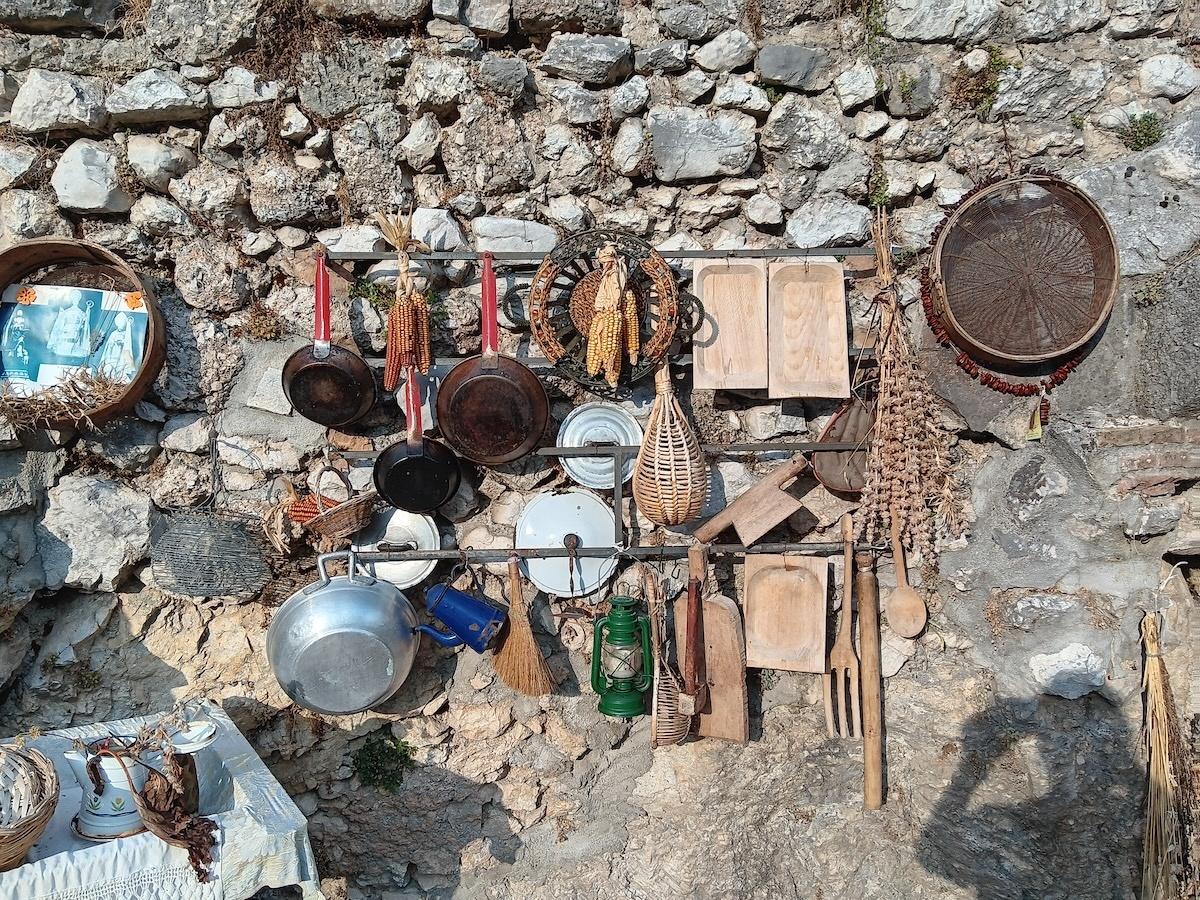 Ancient cooking implements on a stone wall in Villavallelonga, Abruzzo, Italy