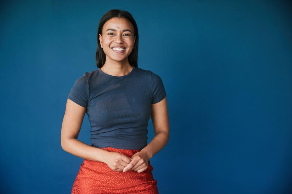 Smiling young businesswoman standing showing that she is a confident potential leader