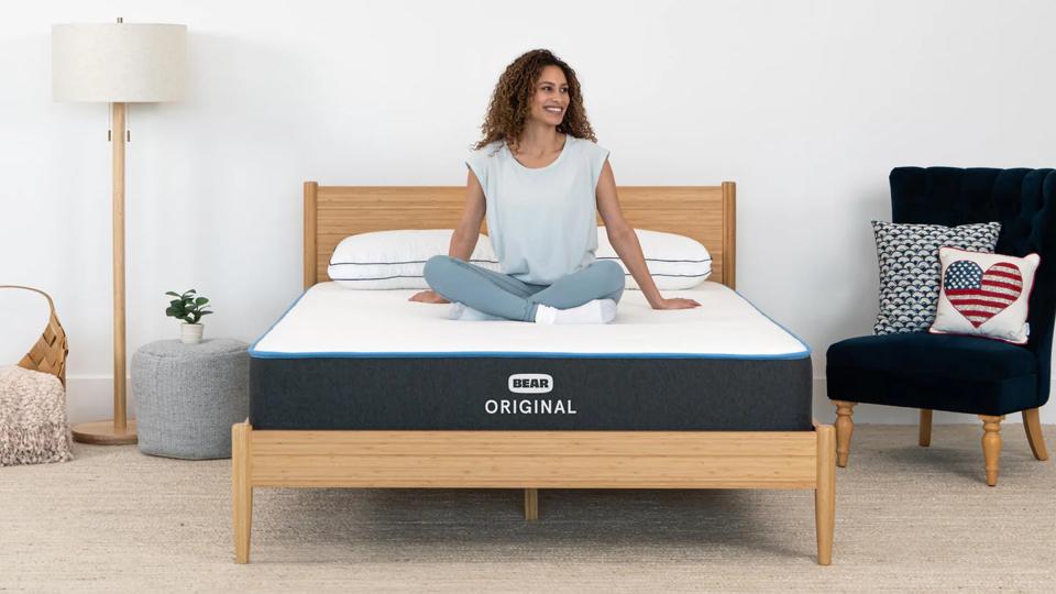 Lifestyle shot of a woman sitting on a Bear Original mattress.