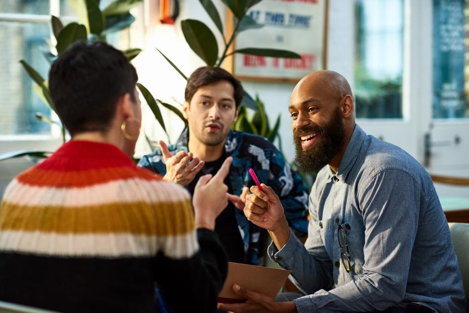 Diverse group of multi-ethnic colleagues in lively discussion in the office