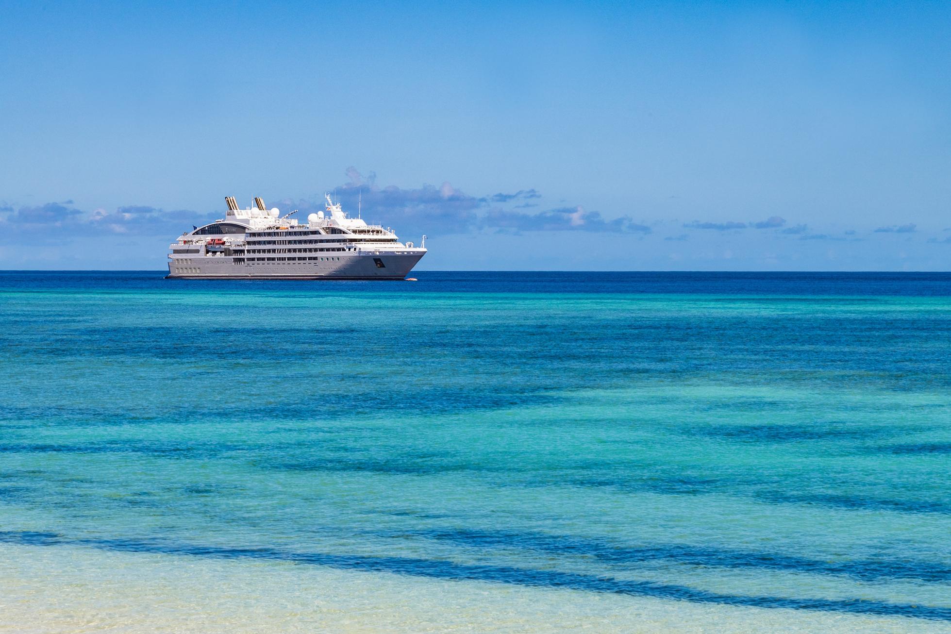 A PONANT luxury cruise liner in the crisp blue and teal ocean.