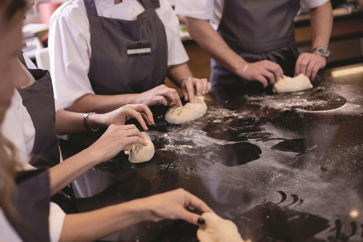 Cooking class guests kneading dough at Le Maoir aux Quat'Saisons, A Belmond Hotel in Oxfordhire