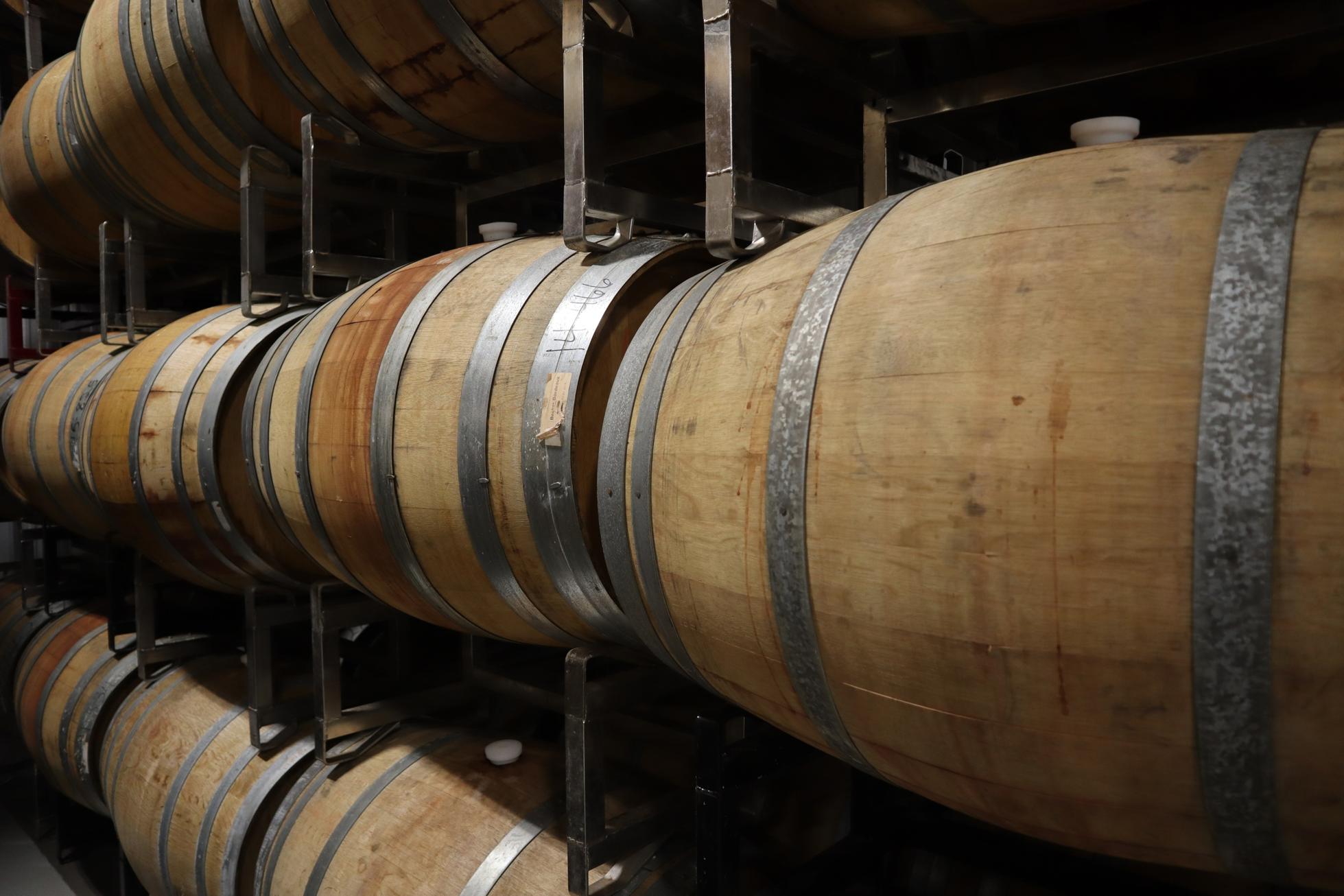 Closeup shot of rows of wine barrels aging wine in a winery in Texas