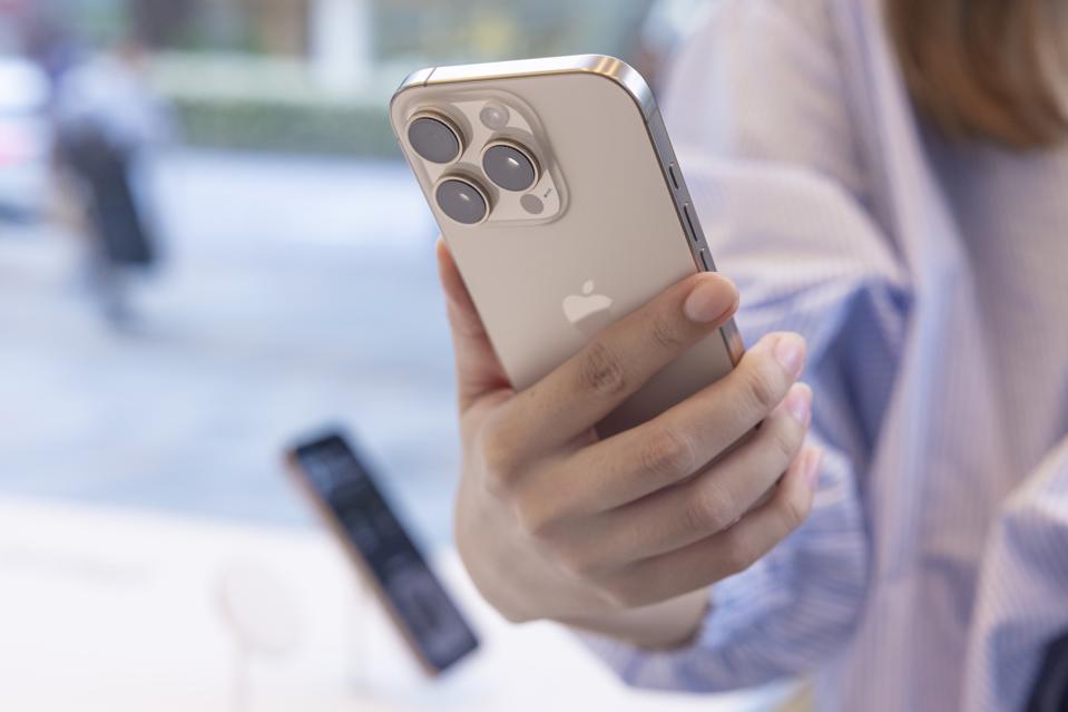 A customer holds the new Apple iPhone 16 Pro in her hand...