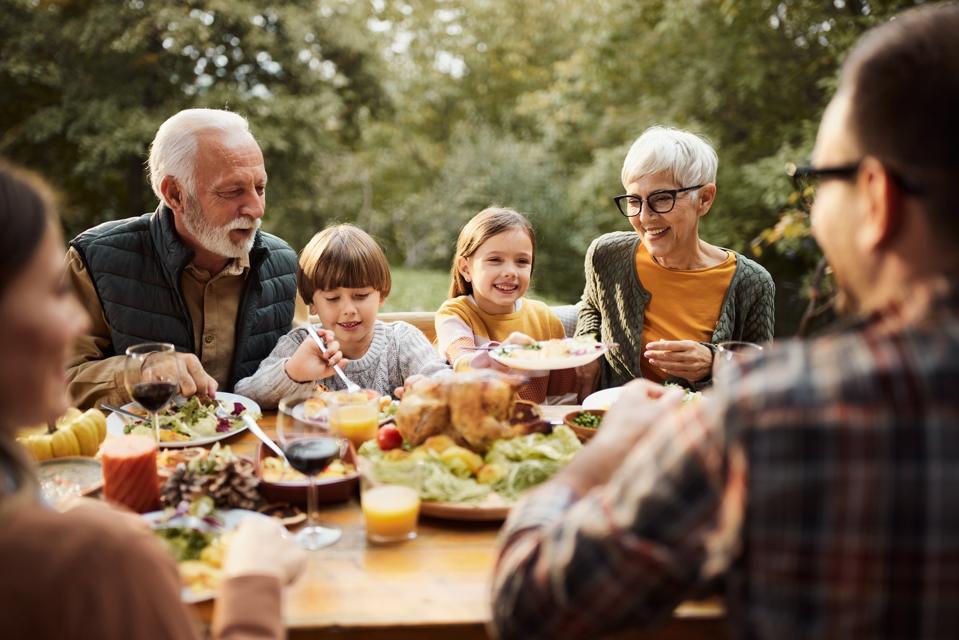 Happy multi-generation family having lunch in nature.
