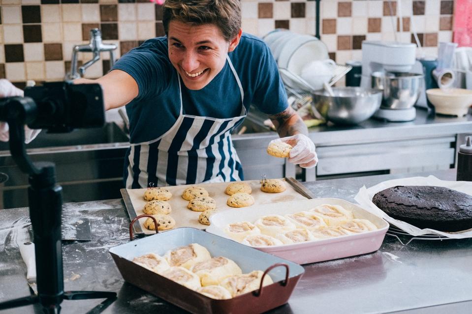 A man blogger live cooking at kitchen for working from home. COVID-19