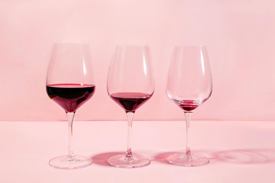 Mindful drinking and alcohol cutback concept. Three glasses with lowering levels of red wine poured