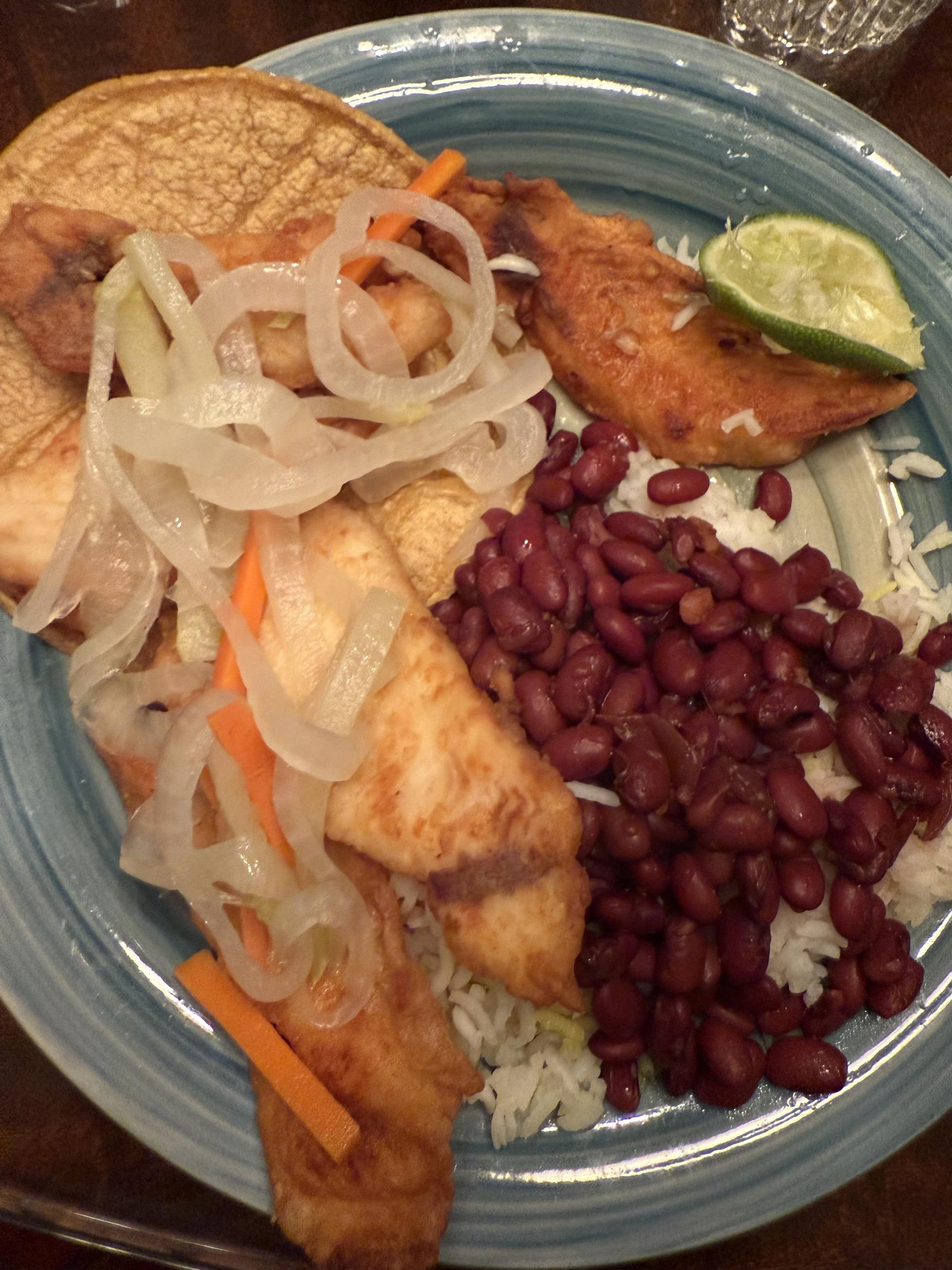 A plate of fried fish and beans.