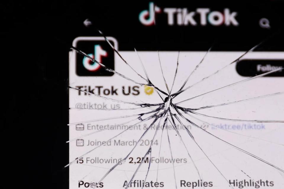 A screenshot of TikTok's U.S. Twitter profile page underneath a cracked phone screen.