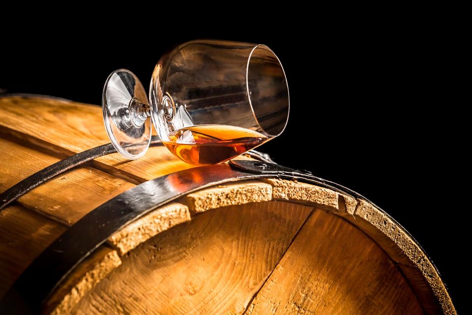 Glass of cognac on the vintage barrel