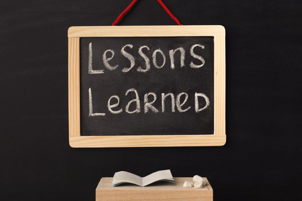 Word lessons learned written on miniature chalkboard