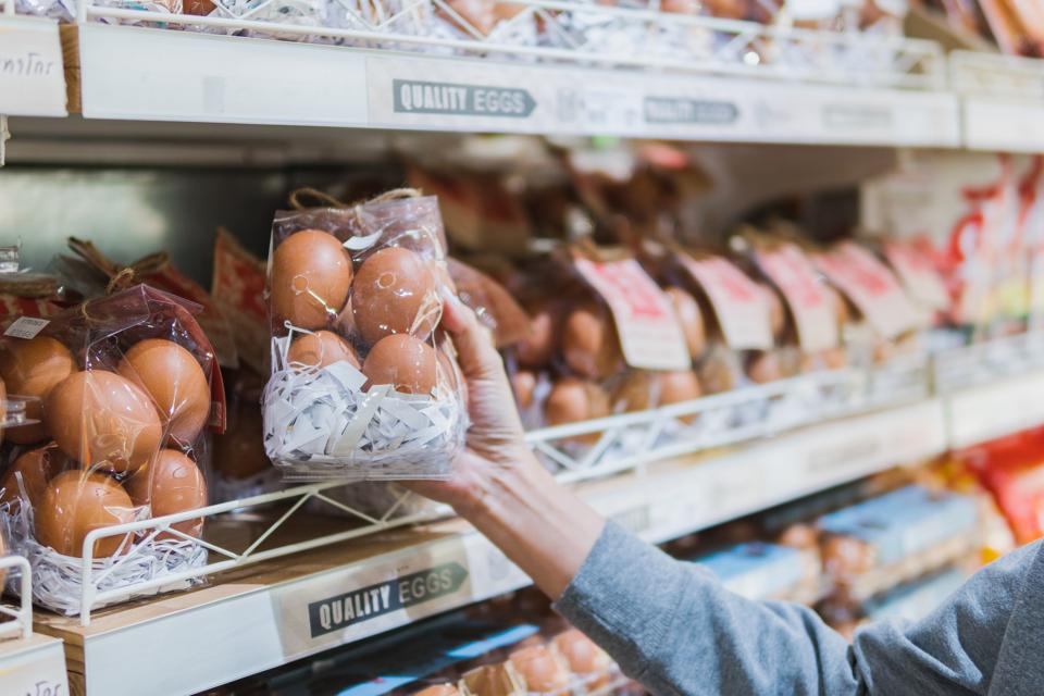 Asian woman holding a shopping basket, Grocery shopping in supermarket. Woman choosing fresh organic egg. Fruits and vegetables shopping. Healthy eating lifestyle. Pesticide Safe food and vegetable selection for life.