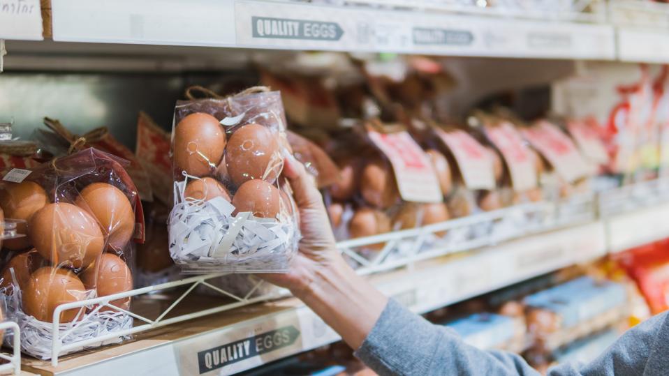 Asian woman holding a shopping basket, Grocery shopping in supermarket. Woman choosing fresh organic egg. Fruits and vegetables shopping. Healthy eating lifestyle. Pesticide Safe food and vegetable selection for life.