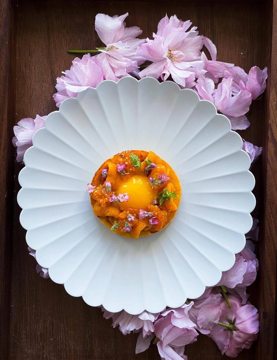 A quail egg, Hokkaido uni and husk cherry on a toasted brioche served at Ikigai.
