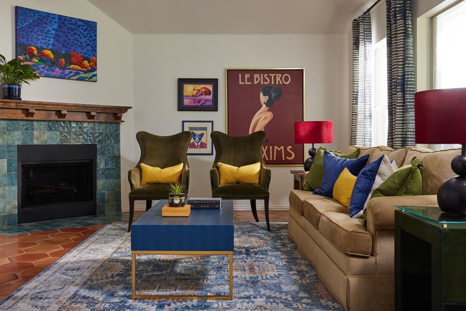 Living room with brown sofa, blue coffee table, two black armchairs with yellow pillows.