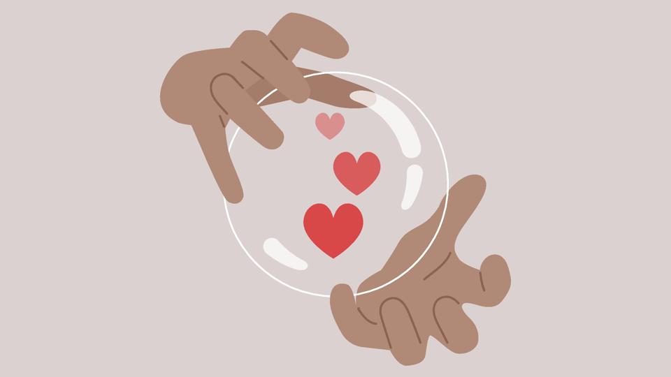 Hands holding a crystal magic ball, a love potion brewing inside