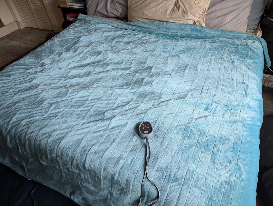 the beautyrest heated blanket in blue on a mattress with its controller on top