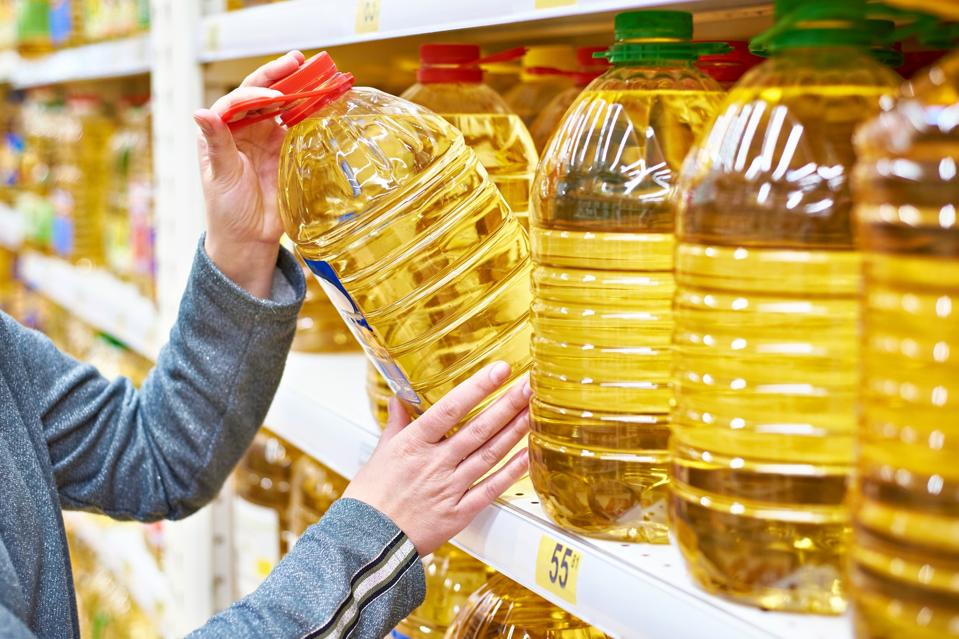 Big bottle of oil in hand buyer at grocery