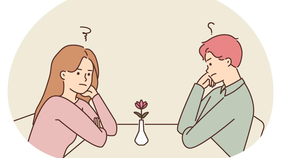 Unhappy man and woman at table in cafe