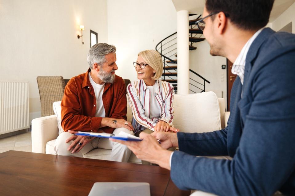 Couple talking with financial advisor at home