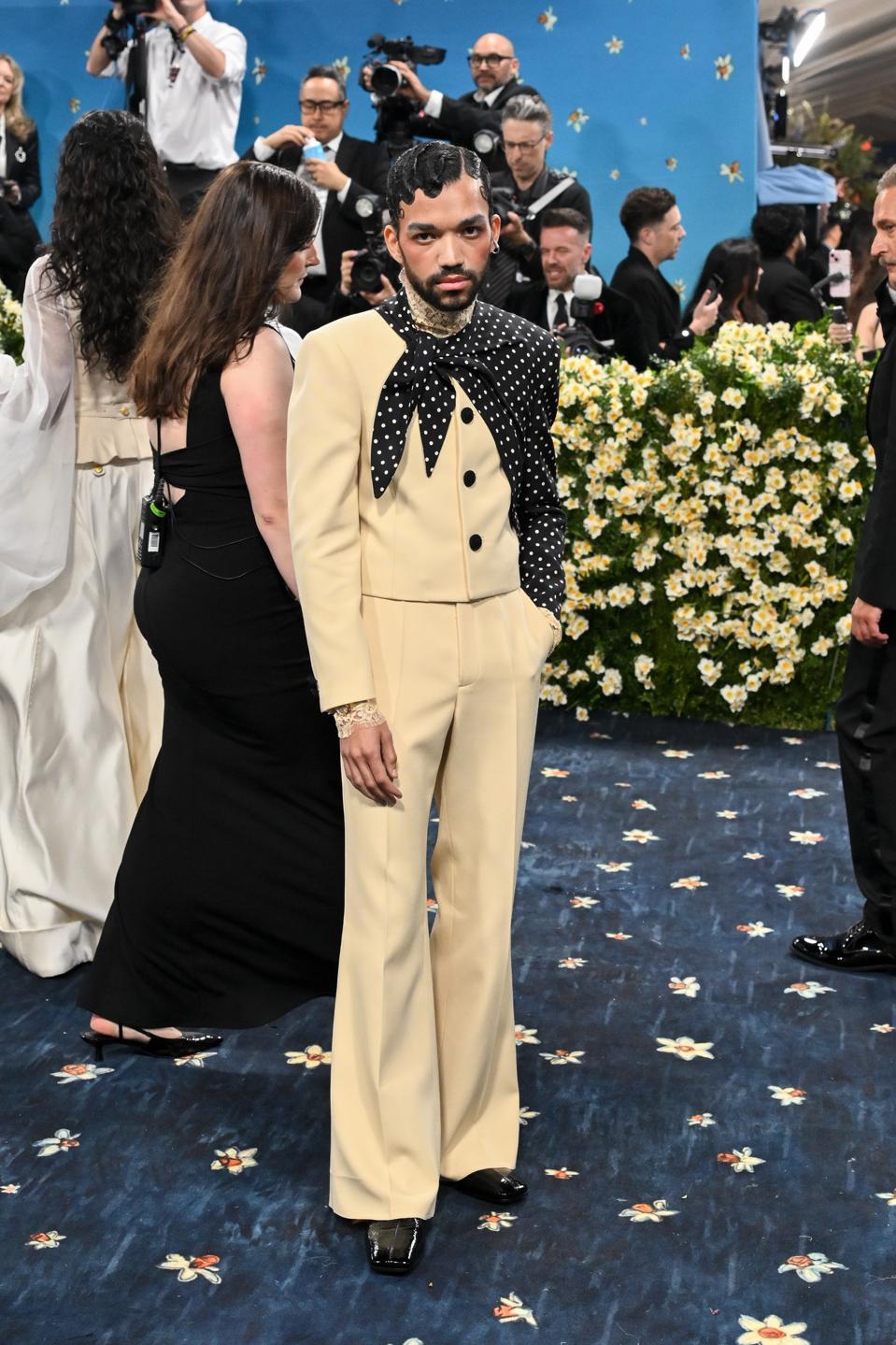 Justice Smith wears an Omega 26mm De Ville Mini Trésor in full 18k Moonshine Gold