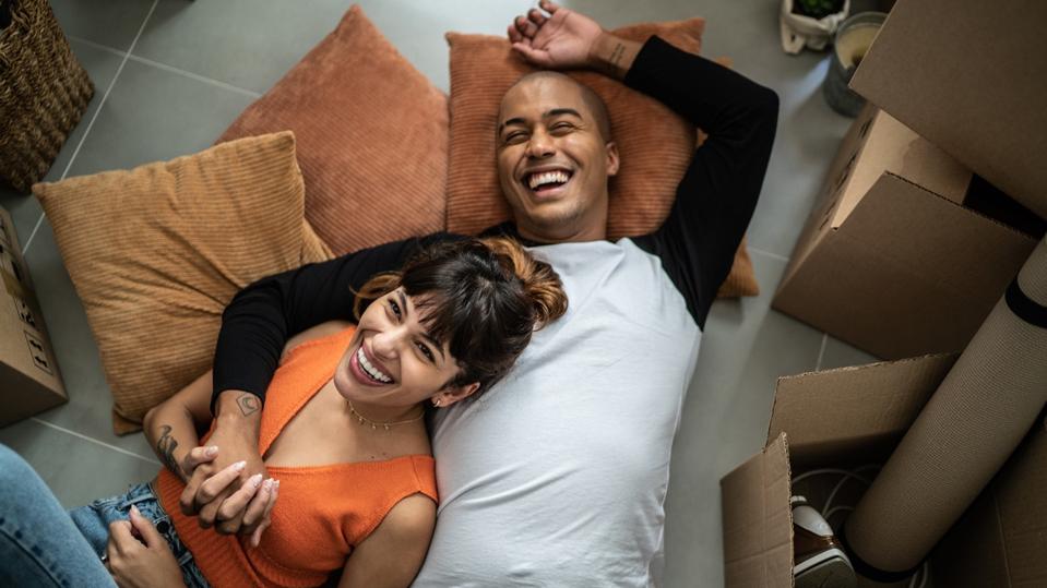 Happy young couple lying on the floor at new home