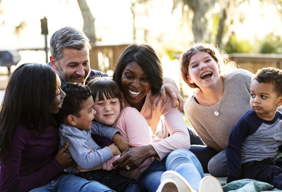 Blended family with five children laughing at the park