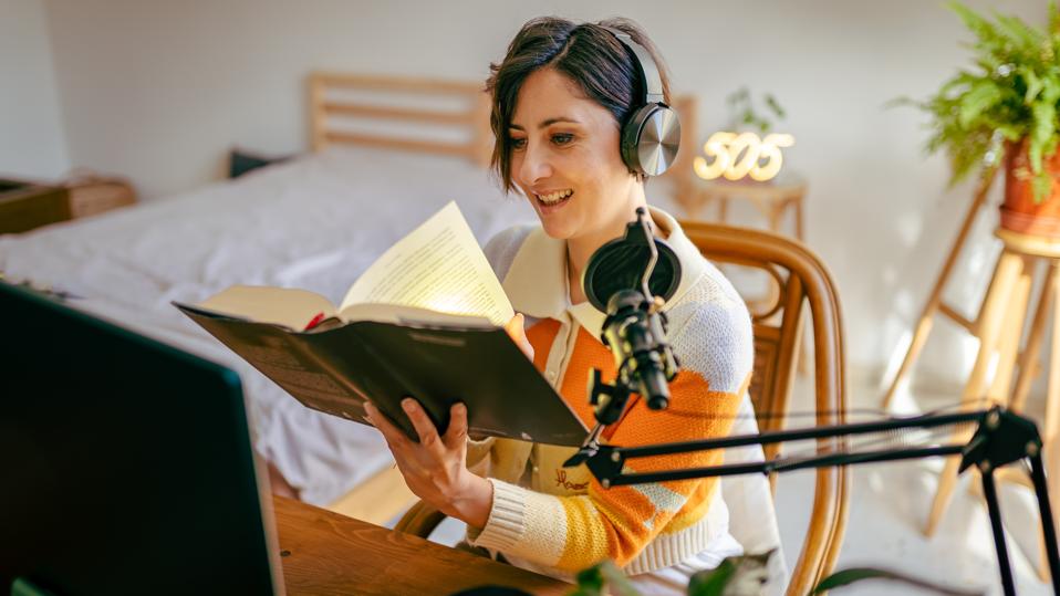 Beautiful young woman recording podcast
