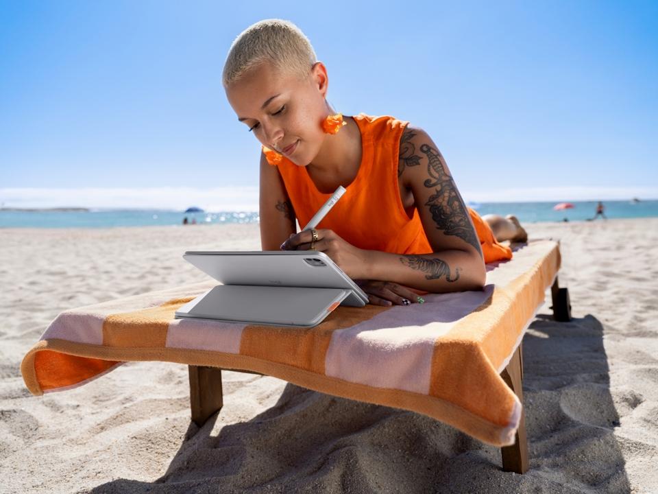 Woman on beach using Logitech Flip Folio and iPad