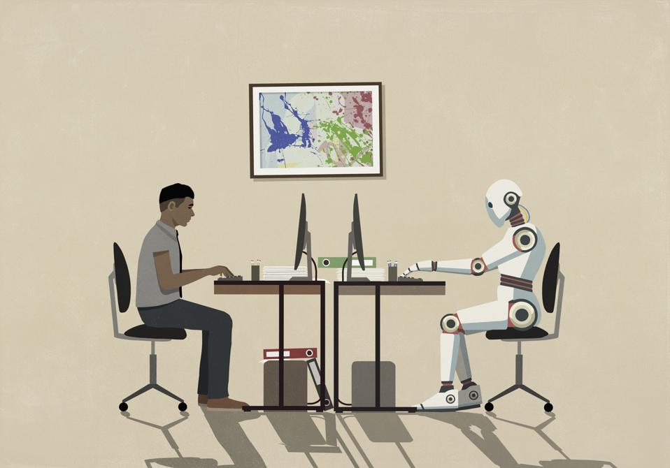 Man and humanoid robot working face to face at computers