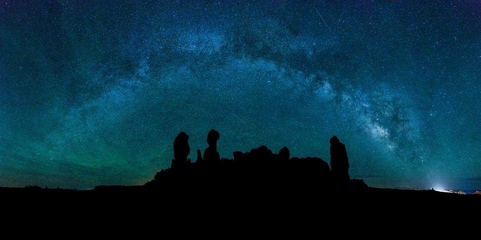 A panoramic image of the Milky Way over the fromations of the Garden of Eden in Arches National Park, Moab, Utah
