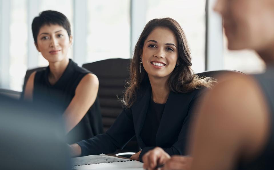 Happy business woman, meeting and discussion with corporate management, collaboration and feedback. Female employee talking to executive team in seminar, office workshop and planning company strategy