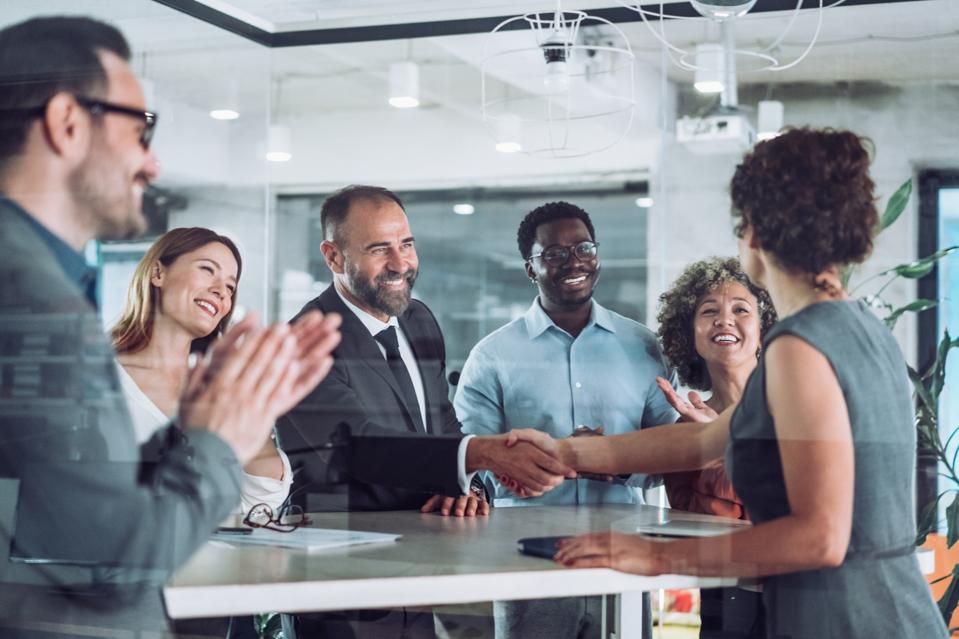 Businesspeople shaking hands across the table.