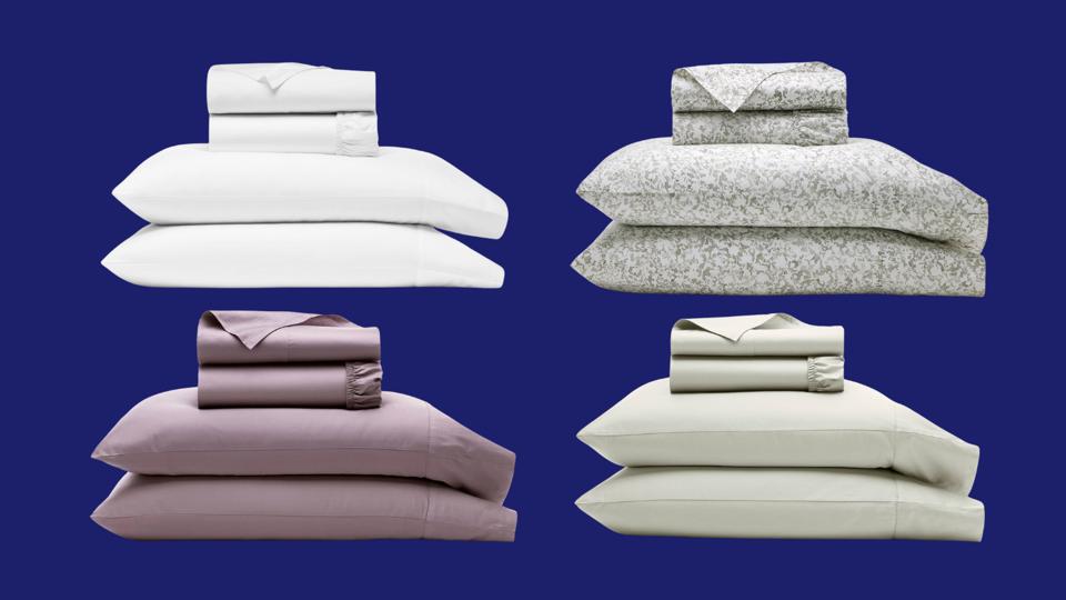 Čtyři různé sady lemovaných listů Boll & Branch v hromadách na modrém pozadí