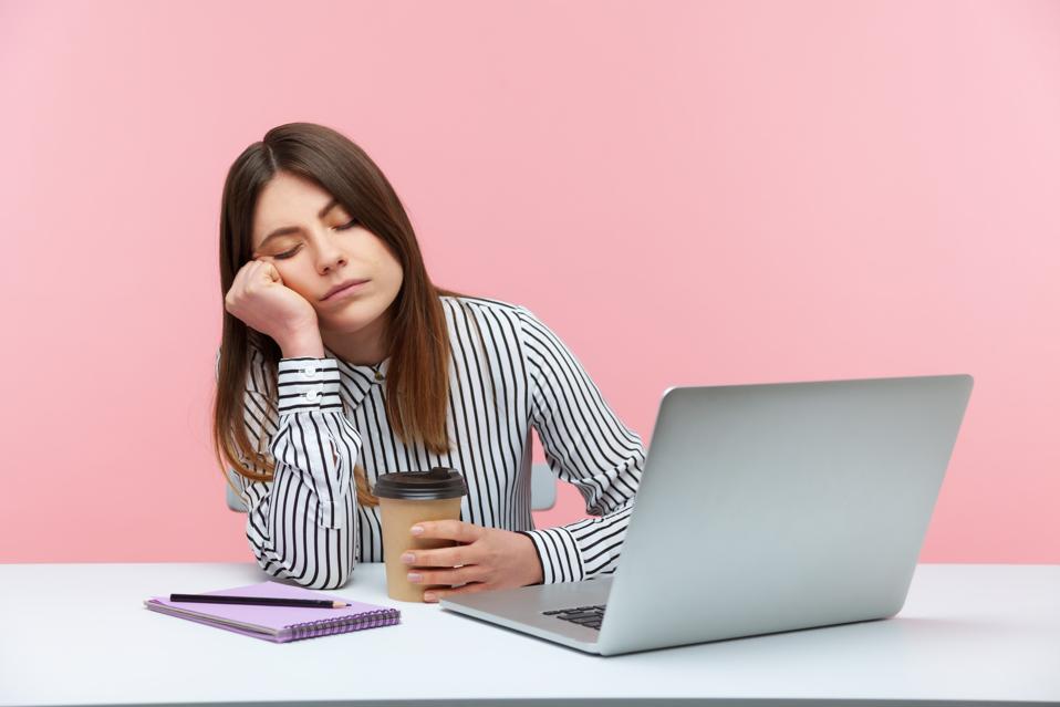 Woman asleep at desk symbolizing burnout and exhaustion in the infinite workday