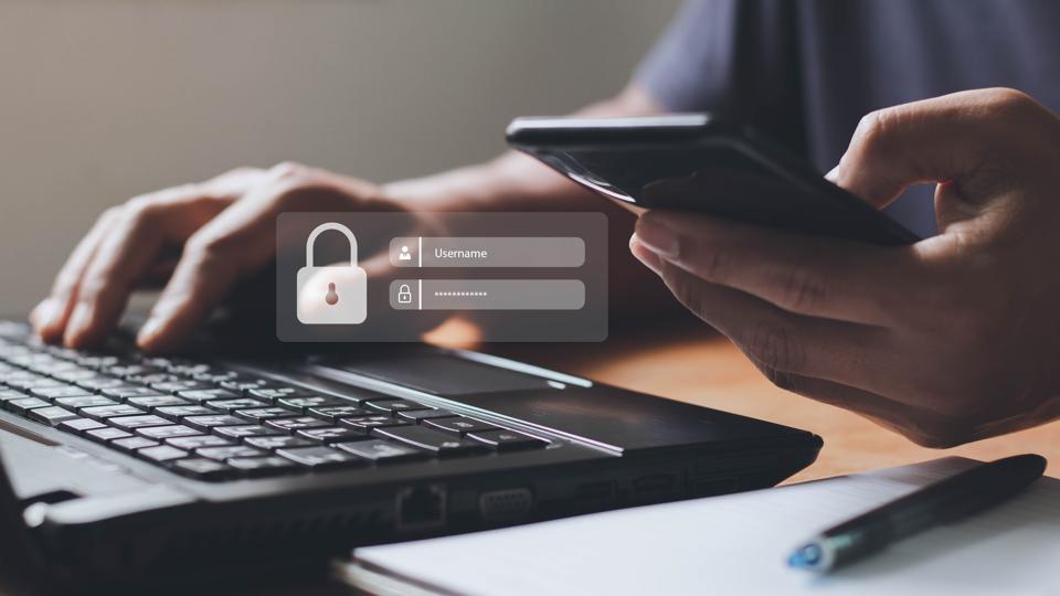 person using laptop and smartphone at same time, login dialog overlaid on image.
