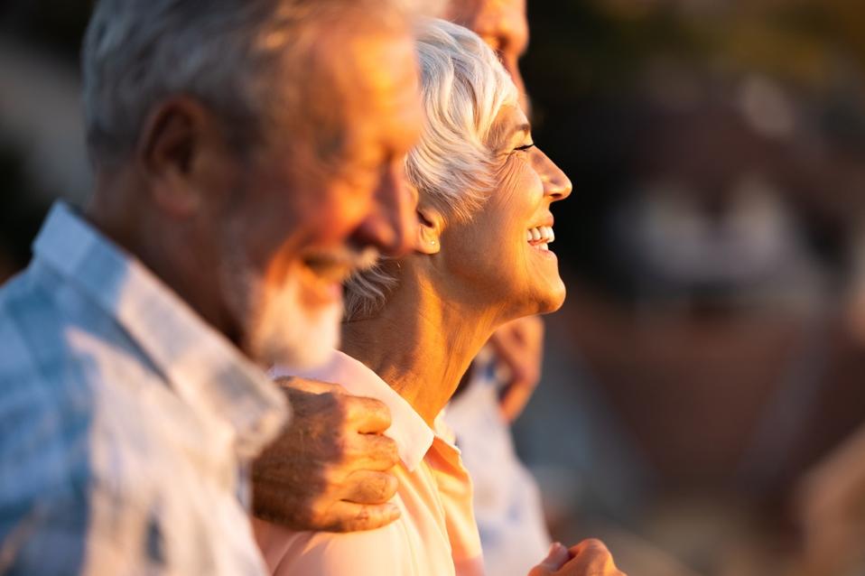 Happy senior woman walking with friends in nature.