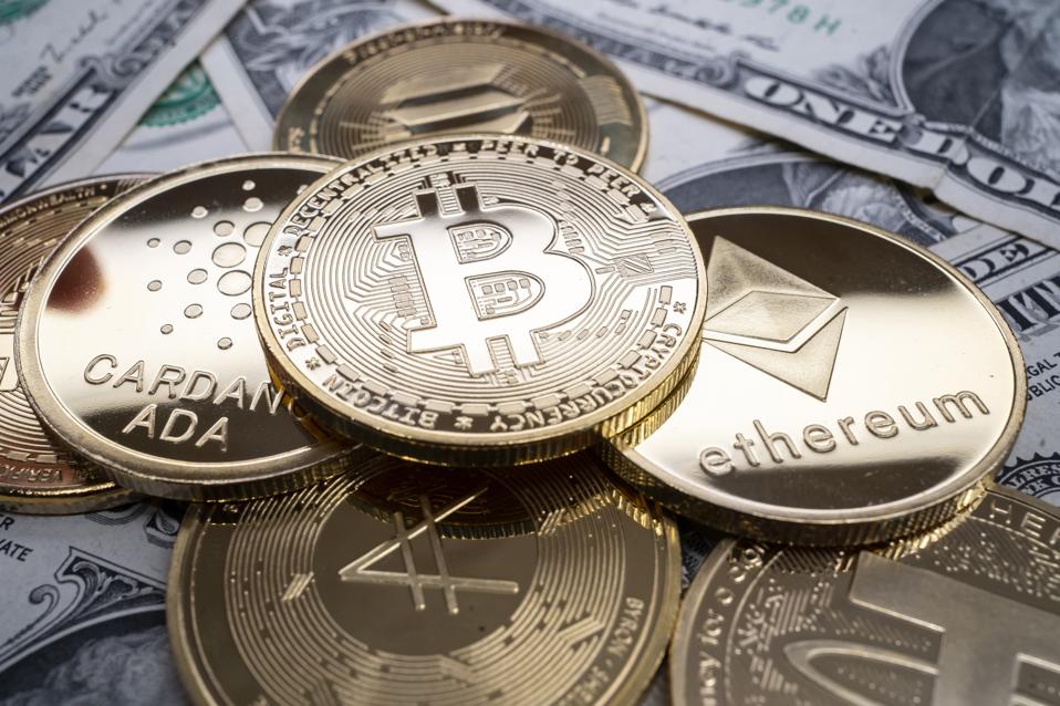 Bitcoin, ether, solana and ada on dollar bills. 