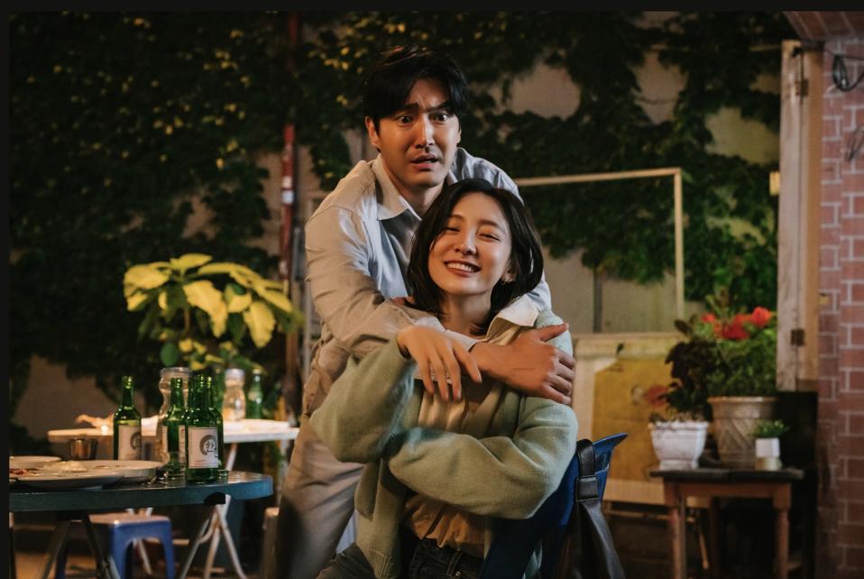 A man looks concerned as a woman tries to embrace him.