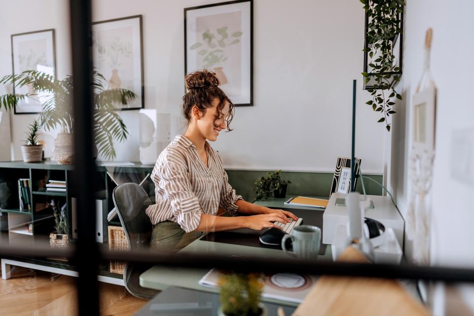 Shot through window of a young woman working in an attractively designed office