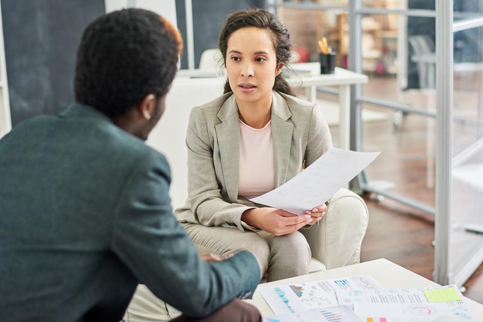 Serious female business consultant working with client