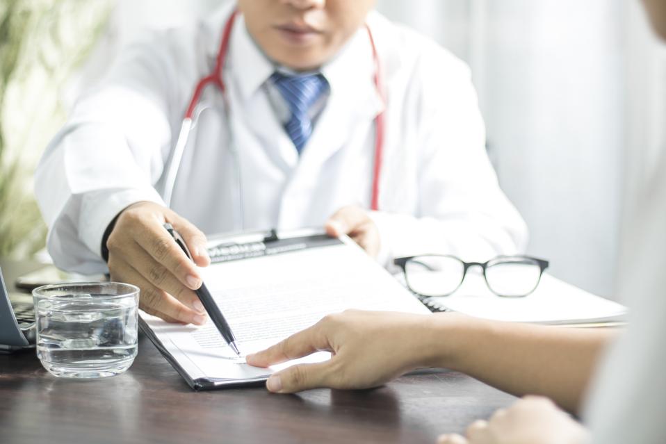 Doctor introduces patient signing on medical records before treat illness in hospital