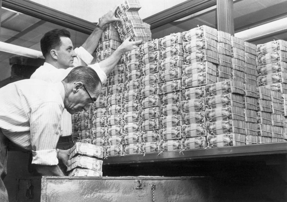 Bank Tellers Piling Stacks of US Dollars