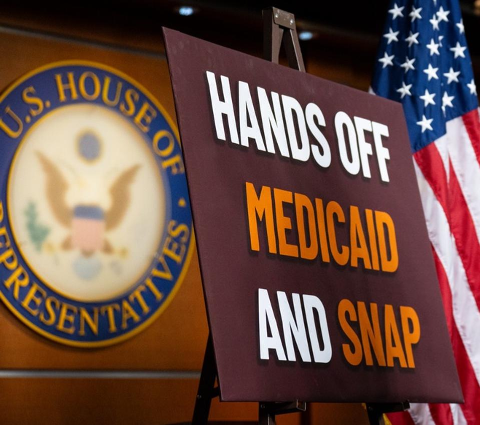 Hands off Medicaid and SNAP poster on stage